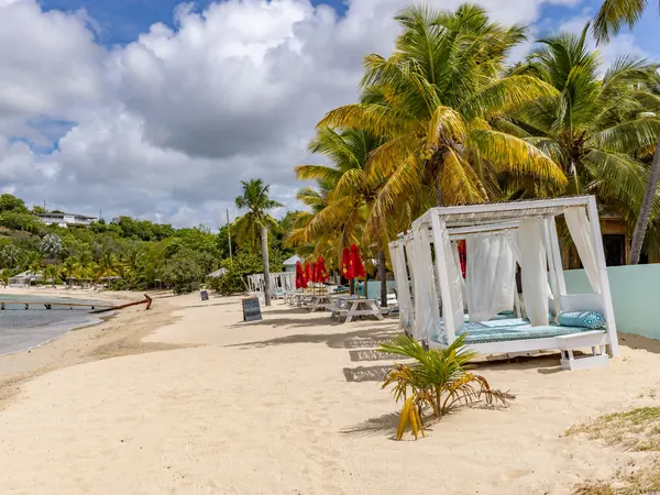 Shaded daybeds on the sand in front of the resort